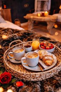 a breakfast tray with cups of coffee and croissants and fruit at L'Evasion Scandinave, SPA XXL, Écran cinéma, Lit king size, day use, 10 min centre in Amiens
