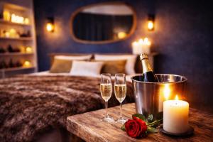 a bedroom with a bed with a bottle of champagne and two glasses at L'Evasion Scandinave, SPA XXL, Écran cinéma, Lit king size, day use, 10 min centre in Amiens