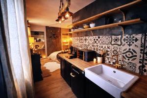 a small kitchen with a sink and a bedroom at L'Evasion Scandinave, SPA XXL, Écran cinéma, Lit king size, day use, 10 min centre in Amiens