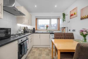 a kitchen with a table and a dining room at Leys Park Executive Apartments in Dunfermline