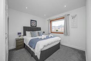 a bedroom with a large bed and a window at Leys Park Executive Apartments in Dunfermline