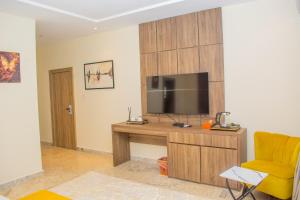 a living room with a television and a yellow chair at House 24 Jahi in Kadobunkuro