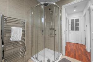 a shower with a glass door in a bathroom at Leys Park Executive Apartments in Dunfermline +23 photos