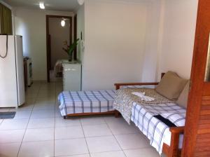 a living room with a bed and a refrigerator at Flats No Sushi in Itacaré