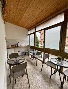 a room with tables and chairs and a large window at Rifugio Urbano in Terni