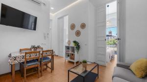 a living room with a couch and a tv on a wall at Apartamentos Alcazaba in Málaga