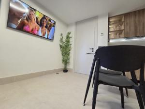a chair in a room with a tv on the wall at Las Campanas de la Catedral Suite Jacuzzi in Burgos