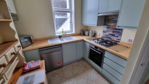 a small kitchen with a sink and a stove at Southsea Escape - 2 double bedrooms apartment - PARKING PERMITS INCLUDED in Portsmouth +15 photos
