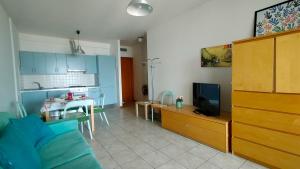 a kitchen and a living room with a couch and a table at Trilocale DIRETTAMENTE SUL MARE CON DUE BAGNI cod 510 in Porto Recanati
