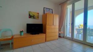 a living room with a tv and a dresser with a dresser at Trilocale DIRETTAMENTE SUL MARE CON DUE BAGNI cod 510 in Porto Recanati +20 photos