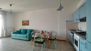 a kitchen with a table and a blue couch at Trilocale DIRETTAMENTE SUL MARE CON DUE BAGNI cod 510 in Porto Recanati