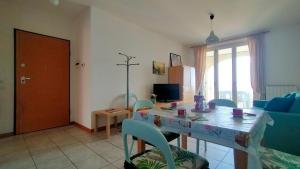 a living room with a table and blue chairs at Trilocale DIRETTAMENTE SUL MARE CON DUE BAGNI cod 510 in Porto Recanati