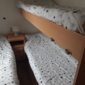 a bedroom with two bunk beds and a night stand at Bungalow a Hyeres prévoir serviettes de toilette et linge de lits in Hyères