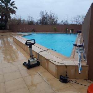 a swimming pool with a camera next to it at Bungalow a Hyeres prévoir serviettes de toilette et linge de lits in Hyères