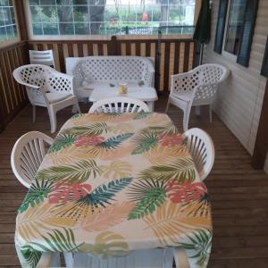 a table and four chairs on a porch at Bungalow a Hyeres prévoir serviettes de toilette et linge de lits in Hyères