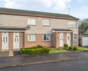 a brick house with white doors on a street at Leys Park Executive Apartments in Dunfermline