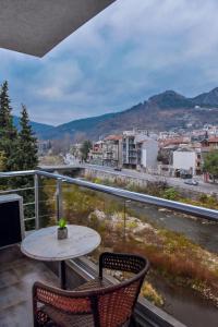 a balcony with a table and chairs and a view of a city at Central Guest Rooms in Asenovgrad
