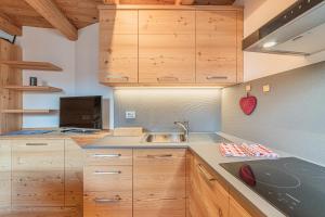 a kitchen with wooden cabinets and a sink at The Love Chalet in Falcade