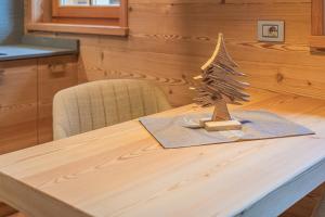 a wooden table with a small christmas tree on it at The Love Chalet in Falcade