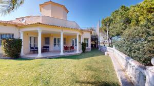 a house with a fence in front of a yard at Greenview Villa by ON Travel in Oliva