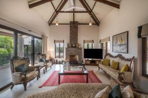 a living room with couches and a fireplace at SaffronStays Casa Amore in Mahabaleshwar