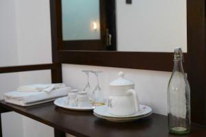 a table with a tea kettle and cups and a bottle at Yala Cherish Inn & Safari in Tissamaharama