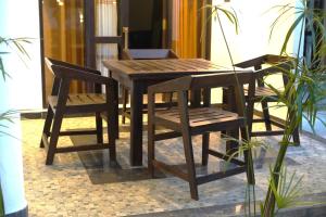 a wooden table and two chairs sitting next to a table and a table and chairs at Yala Cherish Inn & Safari in Tissamaharama +29 photos