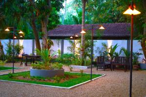 a garden with a table and chairs and trees at Yala Cherish Inn & Safari in Tissamaharama