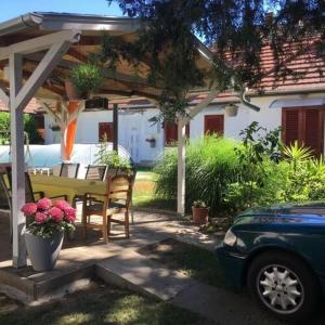 a patio with a table and chairs under a pergola at FLY Vendégház in Szólád