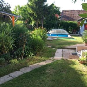 a garden with a boat parked in the yard at FLY Vendégház in Szólád +16 photos