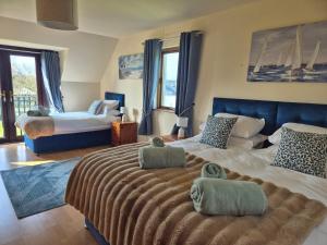 a bedroom with a large bed with two towels on it at Harbour View Lodge in Dromod