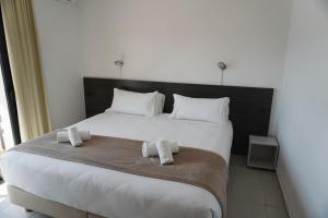 a bedroom with a large white bed with towels on it at Hotel Ram Rooms Tahiti in Salou