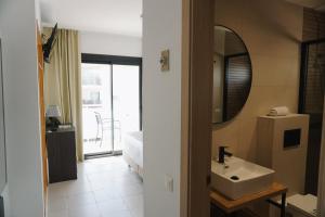 a bathroom with a sink and a mirror at Hotel Ram Rooms Tahiti in Salou