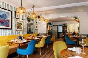 a restaurant with wooden tables and blue chairs at The Bull Hotel in Bridport
