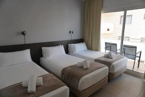 a hotel room with two beds and a window at Hotel Ram Rooms Tahiti in Salou