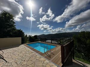 a swimming pool on a wooden deck with the sun in the sky at Villa Jamora in Rivière-Pilote +12 photos