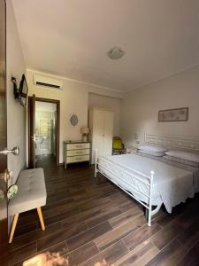 a bedroom with a white bed and a wooden floor at Villa Rosada in Palinuro +33 photos