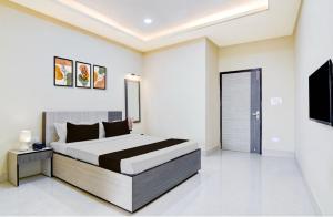 a bedroom with a bed and a flat screen tv at Townhouse Oak Howrah Junction Kolkata in Kolkata
