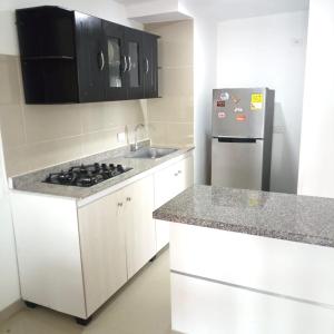 a kitchen with white cabinets and a stainless steel refrigerator at casa trieste in Jamundí