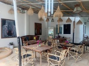 a dining room with wooden tables and chairs at POLE-INN VILLA Nungwi Zanzibar in Nungwi