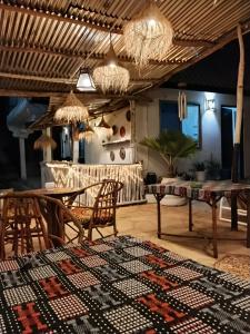 a living room with a table and chairs and a rug at POLE-INN VILLA Nungwi Zanzibar in Nungwi
