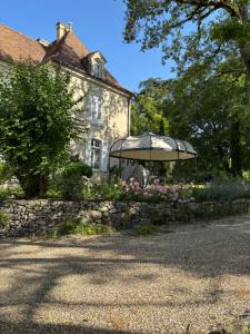 a house with an umbrella in front of it at Château de Foussal in Issigeac