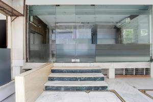a lobby with stairs and a glass wall at Collection O MP Nagar in Bhopal