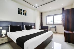 a bedroom with a large bed and a window at Collection O MP Nagar in Bhopal +39 photos
