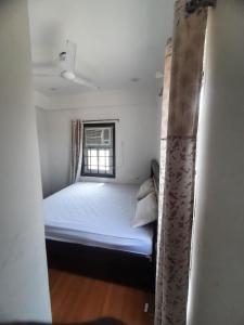 a small bedroom with a bed and a window at Hotel Aditya Bikaner in Deshnoke