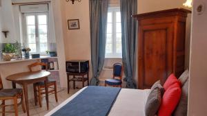 a bedroom with a bed and a table and chairs at Studio De La Mer in Arromanches-les-Bains
