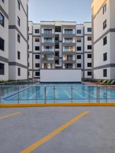 a swimming pool in a parking lot in front of buildings at Oceania Suites 5 Minutes from Jomo Kenyatta international Airport in Nairobi