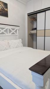 a bedroom with a white bed with a black counter at Oceania Suites 5 Minutes from Jomo Kenyatta international Airport in Nairobi +13 photos