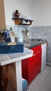 a kitchen with red cabinets and a counter top at Studio De La Mer in Arromanches-les-Bains +9 photos