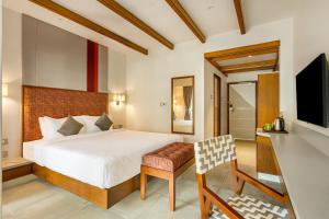 a bedroom with a bed and a desk and a television at Mango Hill Hotel Velankanni in Velankanni